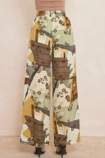 Printed high waisted wide leg pants featuring elastic drawstring waist. Pocket at sides.